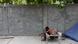 Indien Neu Delhi: Ein Mann sitzt neben einer Mauer auf einem Bettgestell auf dem Bürgersteig Indien Neu Delhi: Ein Mann sitzt neben einer Mauer auf einem Bettgestell auf dem Bürgersteig