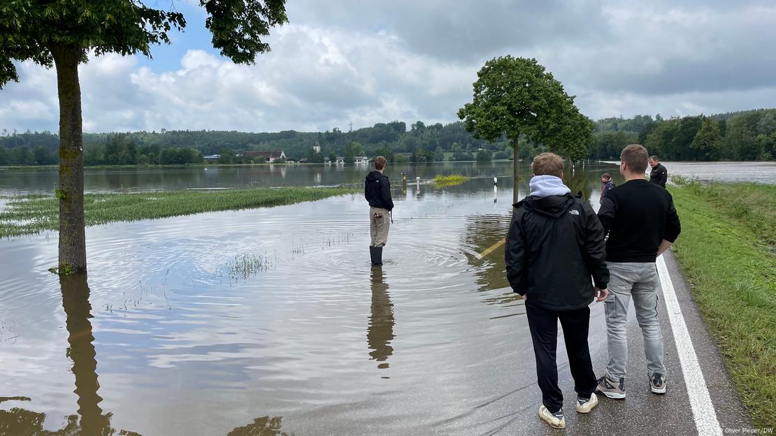 Menschen stehen mit Gummistiefeln im Wasser