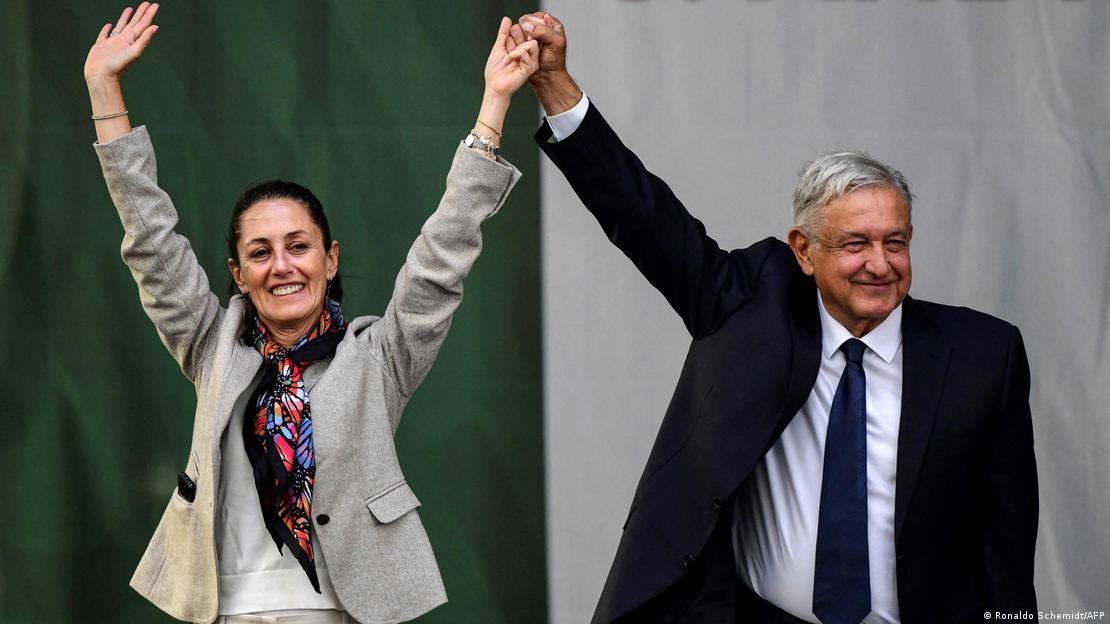 O presidente mexicano, Andrés Manuel López Obrador (à direita), e a então prefeita da Cidade do México, Claudia Sheinbaum, acenam para os apoiadores após apresentarem seu relatório de governo, na praça Zócalo, na Cidade do México, em 1º de julho de 2019