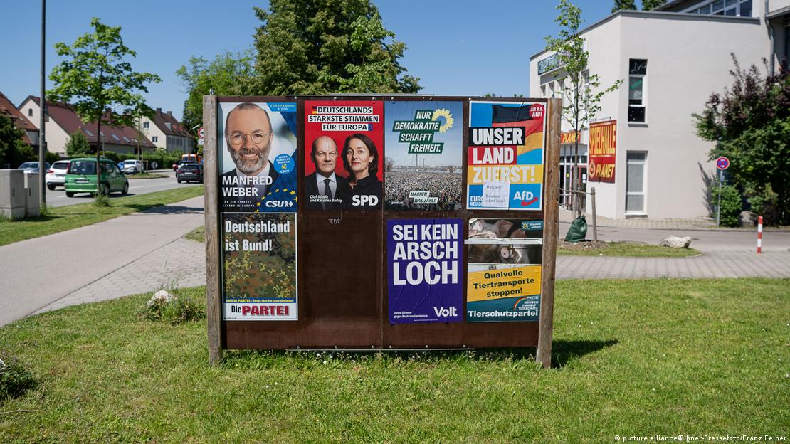 Një mur provizor me postera të ndryshëm politik për zgjedhjet e Parlamentit Evropian 2024 në Gjermani: CSU (Bavaria) me Manfred Weber, slogani: "Për një Bavari të fortë në Evropë"; SPD me Olaf Scholz dhe Katarina Barley, slogani: "Zërat më të fortë të Gjermanisë për Evropën"; Die Grünen, slogani: "Vetëm demokracia krijon liri"; AfD, slogani: "Vendi ynë i pari"; Die Partei, (Partia) slogani: "Gjermania është federatë"; VOLT, slogani: "Mos u bë budalla"; dhe Tierschutzpartei (Partia e mbrojtjes së kafshëve), slogani: "Stop transportet e kafshëve me dhimbje".