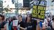 A woman holds up a sign reading 'Hey Joe! Mr. Biden, help us save them' A woman holds up a sign reading 'Hey Joe! Mr. Biden, help us save them'