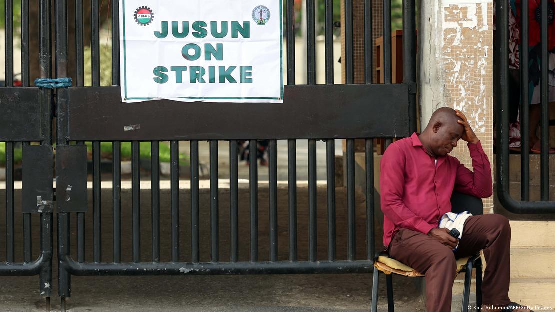 A man seated at a gate with a sign that reads: "Jusun on strike"