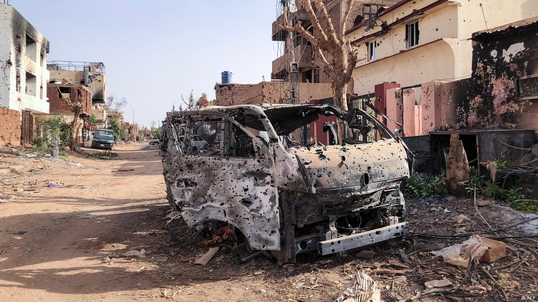 A burnt vehicle in front of damaged shop in Omdurman, Sudan. 