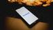 A phone with the Facebook app open, sitting on top of a laptop A phone with the Facebook app open, sitting on top of a laptop