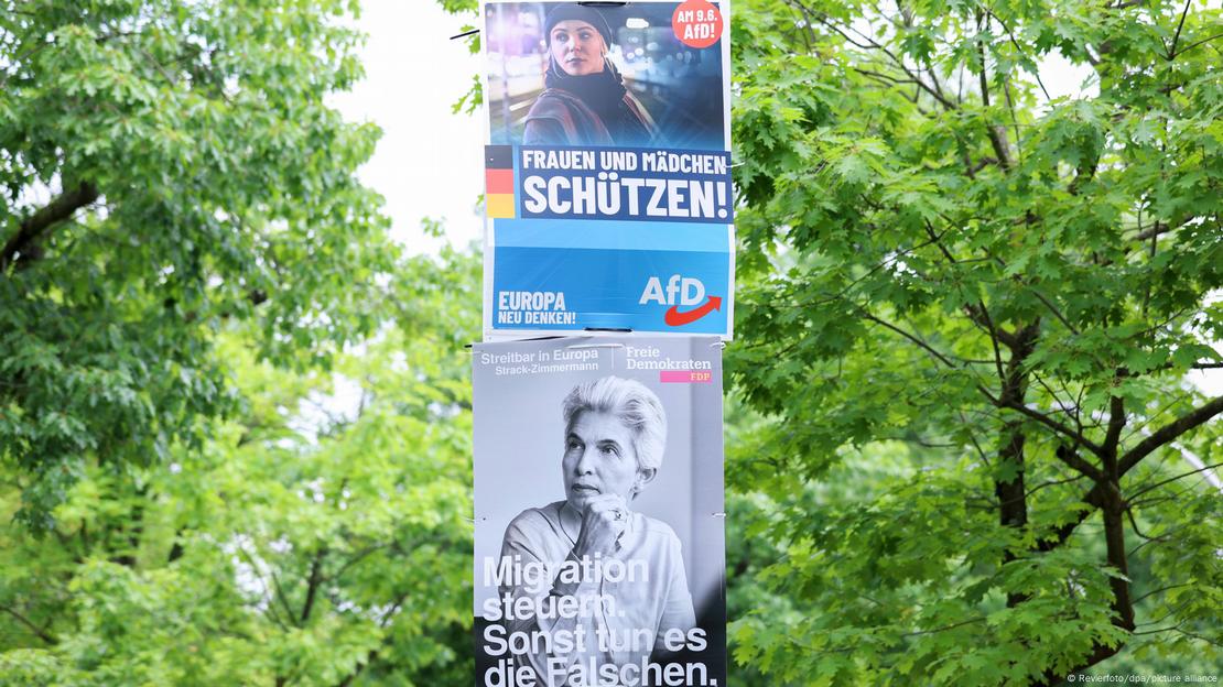 Vor Laubbäumen hängen übereinander zwei Wahlplakate von AfD und FDP