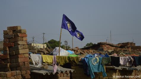 Shanties of brick kiln workers in India fly flags with symbols of Dalit resistance
