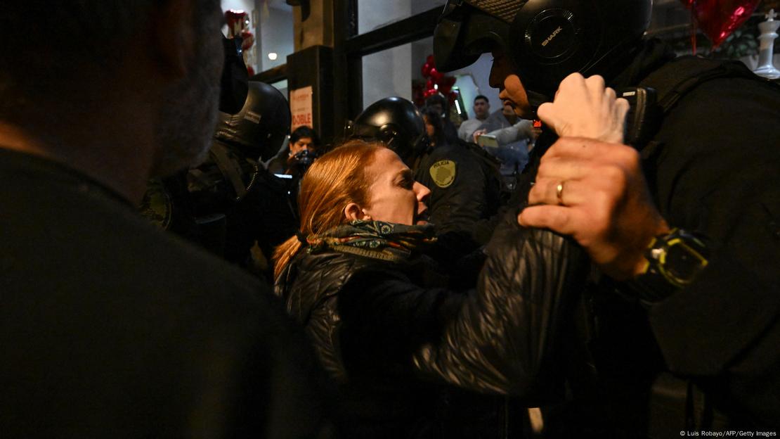 Un policía toma de la muñeca a una manifestante en Buenos Aires.