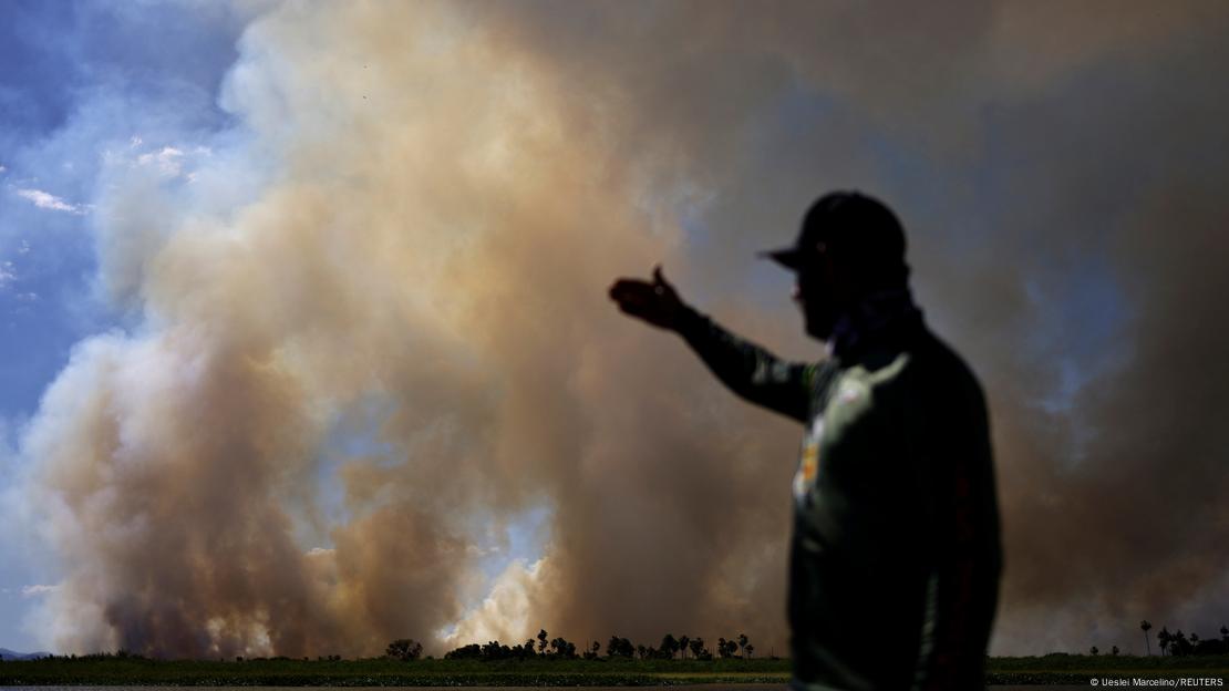 Homem observa fumaça de incêndio no Pantanal