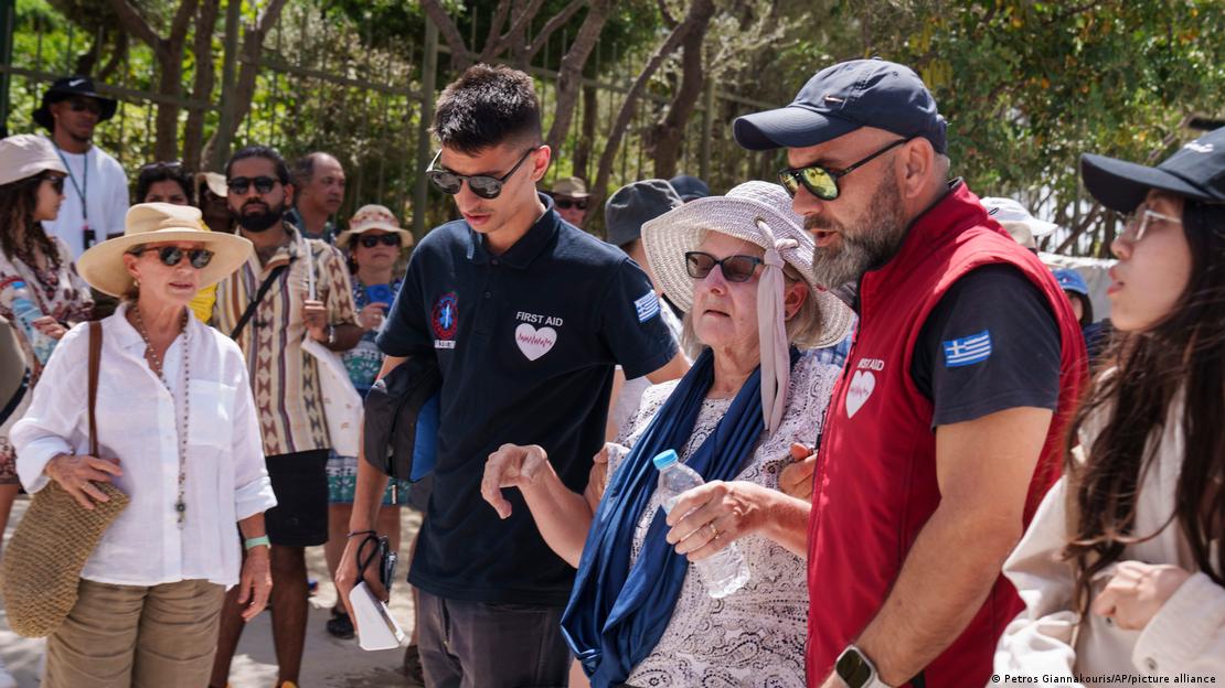 A tourist is helped by first aid personnel from ancient Acropolis site, in central Athens