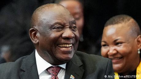 Auf dem Bild sieht man Cyril Ramaphosa, den Präsidenten Südafrikas. Im Hintergrund sind unscharf weitere Personen zu erkennen. 