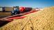 A tractor is passing by a fully loaded grain trailer after unloading soybeans A tractor is passing by a fully loaded grain trailer after unloading soybeans
