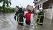 Un pompier guide un résident à travers les eaux de crue à Cocody Angre à Abidjan le 14 juin 2024 après des pluies torrentielles Un pompier guide un résident à travers les eaux de crue à Cocody Angre à Abidjan le 14 juin 2024 après des pluies torrentielles