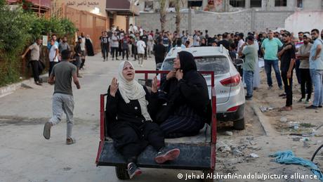 Das Bild zeigt vertriebene Palästinenser und Palästinenserinnen, die nach einem Luftangriff um ihre um ihre Angehörigen trauern.