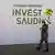 Businessmen stroll in front of the Saudi invest pavilion presenting the Neom project at Mipim in Cannes, France.