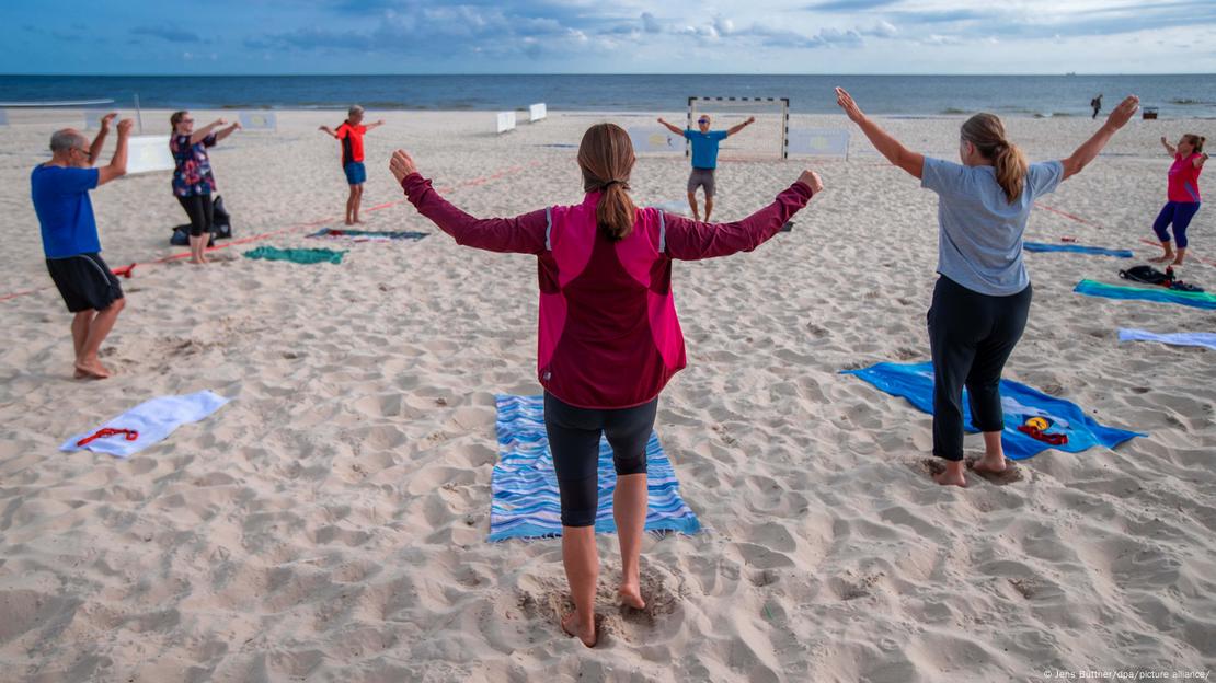 Personas haciendo ejercicio en la playa.