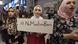 Mulher segura cartaz com frase "Não ao banimento de muçulmanos" Mulher segura cartaz com frase "Não ao banimento de muçulmanos"