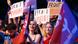 A group of supporters holds up signs and flags that read 'Union Populaire' and 'Front Populaire' A group of supporters holds up signs and flags that read 'Union Populaire' and 'Front Populaire'