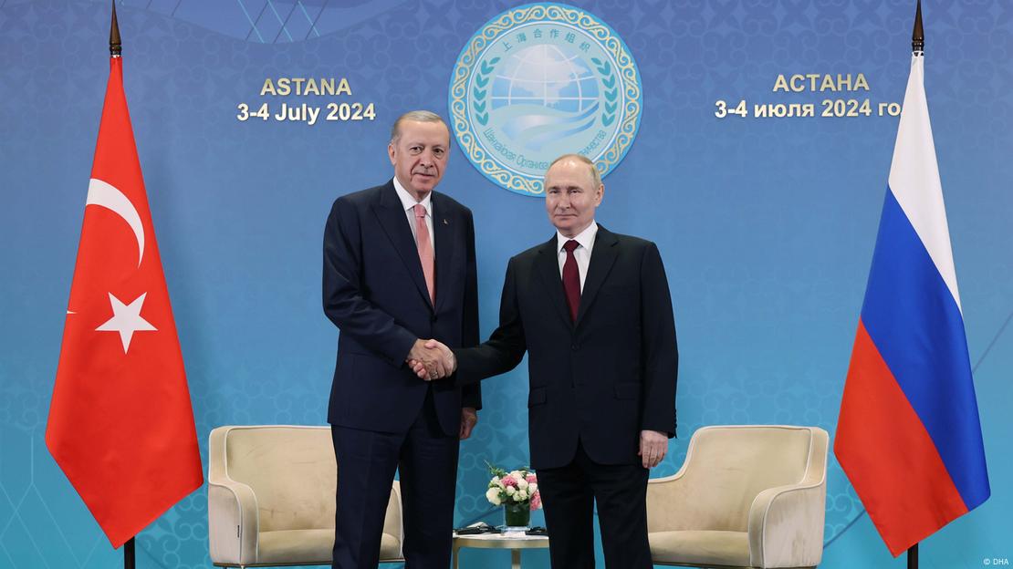 Erdogan und Putin schütteln in Astana vor Sesseln und Flaggen ihrer Länder die Hände