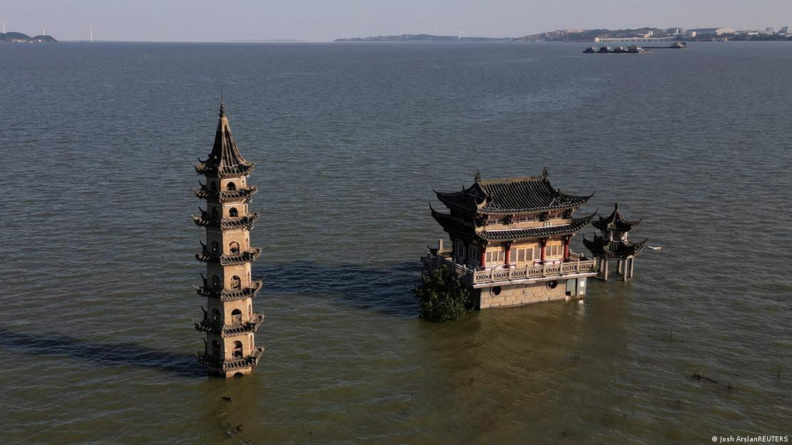 Vista aérea desde un dron de un templo en una isla del lago, del que la torre y una pagoda emergen directamente del agua.