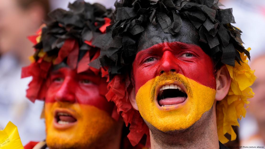 Zwei Deutschland-Fans mit schwarz-rot-goldenen Gesichtern.