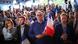 A group of people, many holding French flags, with looks of shock and dismay on their faces A group of people, many holding French flags, with looks of shock and dismay on their faces