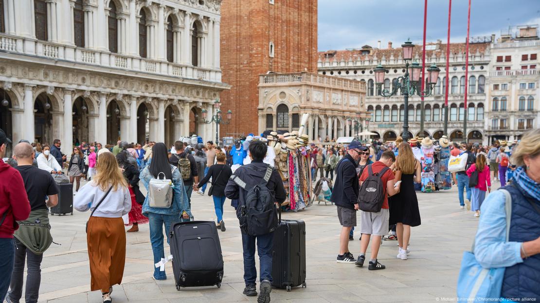 Rrugë në Venecia mbushur me turistë duke tërhequr valizhe