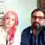 Picture of a woman with long hair dyed pink and a man dressed in a blue suit wearing spectacles. Both look disconsolately at the camera.