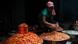 A woman fill tubs with red chillies at a market stall A woman fill tubs with red chillies at a market stall
