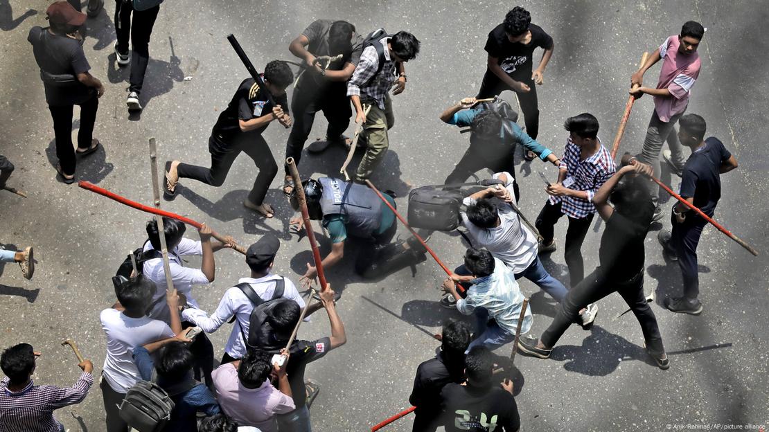 A group of protesters hits a kneeling police officer with sticks and metal pipes