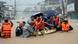 Rescuers assist residents on a boat as they wade through a flooded road Rescuers assist residents on a boat as they wade through a flooded road