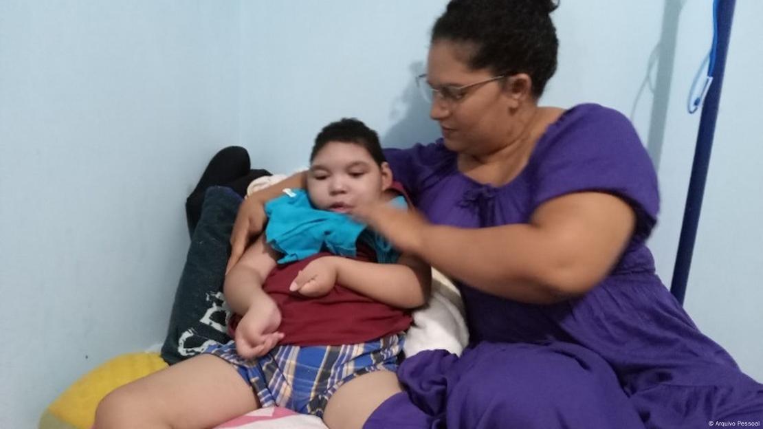 Mulher cuida de menino portador de deficiência