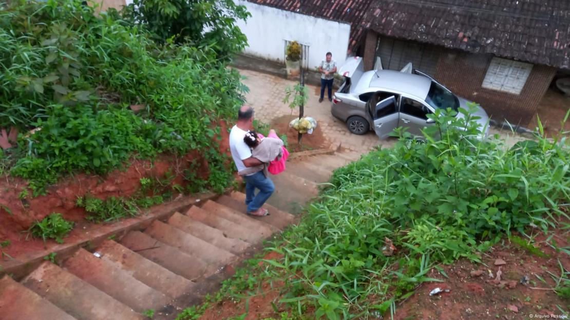 Homem carrega criança escada abaixo