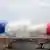 Una explosión de humo con los colores azul, blanco y rojo de la bandera francesa, en la inauguración de los Juegos Olímpicos Paris 2024 el viernes (26.07.2024)