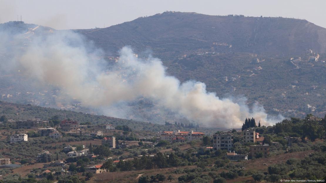 Fumaça sai de povoado em área montanhosa