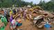 Rescuers and other stand amid debris after landslides in India Rescuers and other stand amid debris after landslides in India