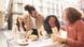 Amigos riem em uma mesa com café e croissants Amigos riem em uma mesa com café e croissants