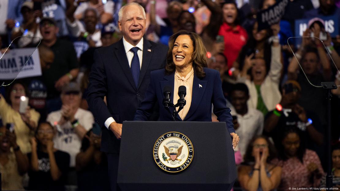 Walz e Kamala Harris sorriem em um púlpito