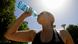 A woman drinks water from a bottle amid a heatwave in Italy A woman drinks water from a bottle amid a heatwave in Italy