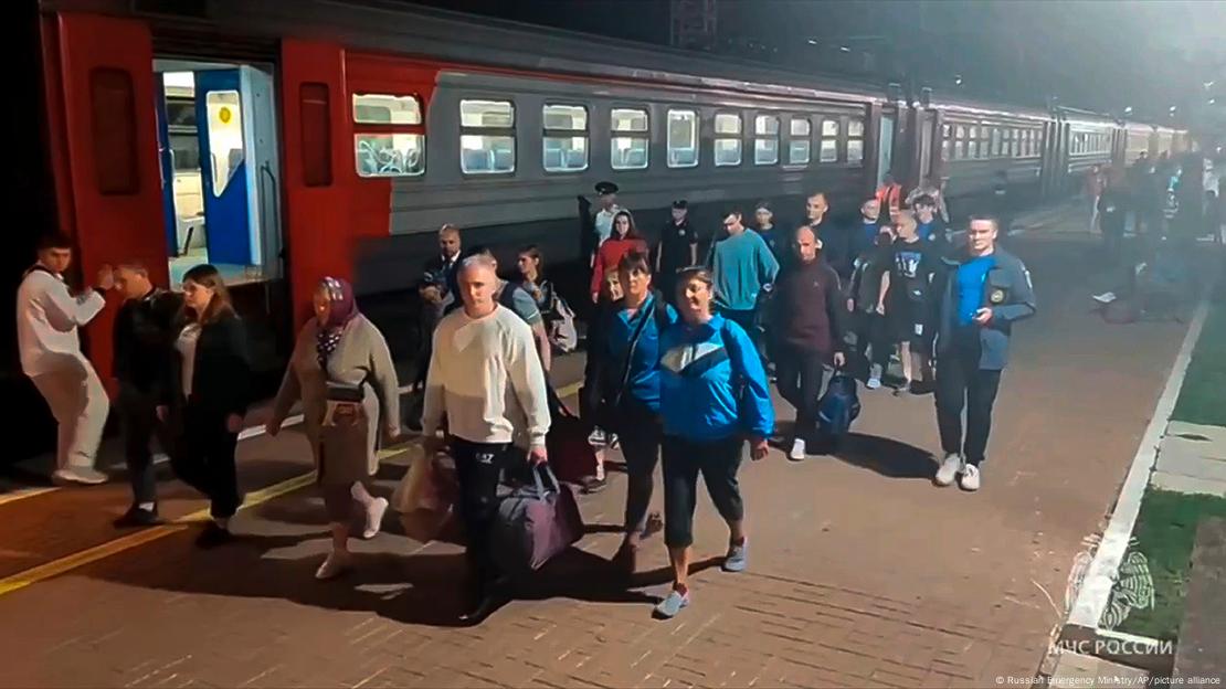 Cidadãos russos adultos carregam malas em estação de trem 