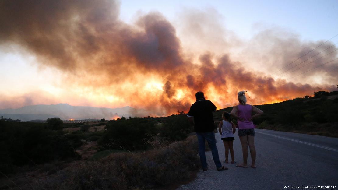 Incendios forestales cerca de Atenas: una familia mira las llamas en el horizonte.