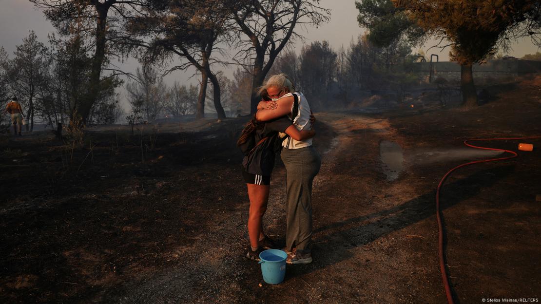 Dos personas se abrazan en Varnava. Muchos tuvieron que dejar sus hogares por el fuego.