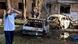 A man reacts while standing next to charred remains of cars in the courtyard of a residential building A man reacts while standing next to charred remains of cars in the courtyard of a residential building