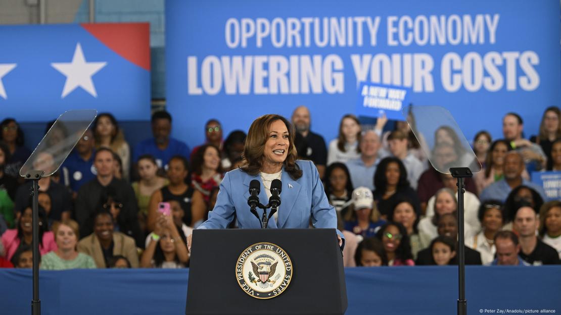 Kamala Harris fala em púlpito, com apoiadores ao fundo