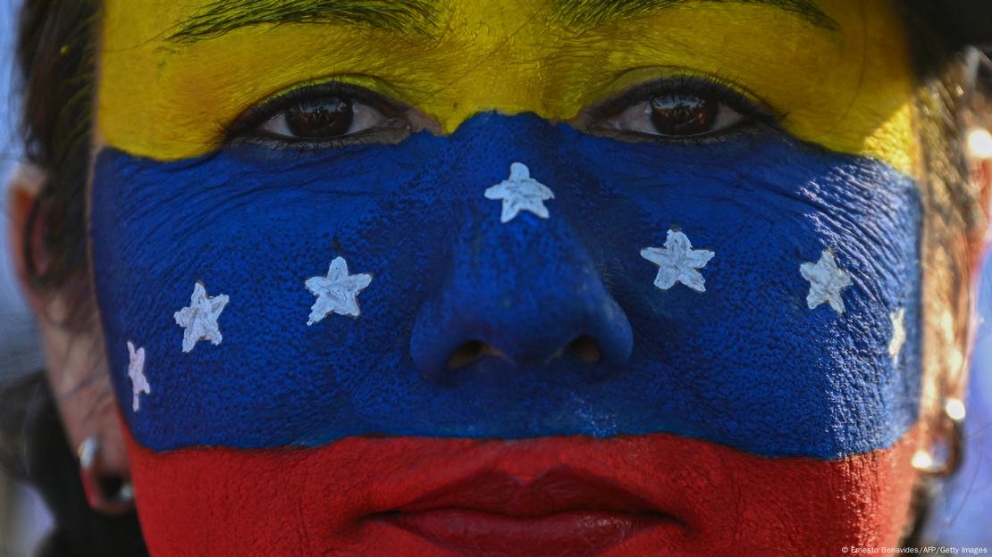 Foto de una persona que lleva la bandera de Venezuela pintada en su cara. Foto de una persona que lleva la bandera de Venezuela pintada en su cara.