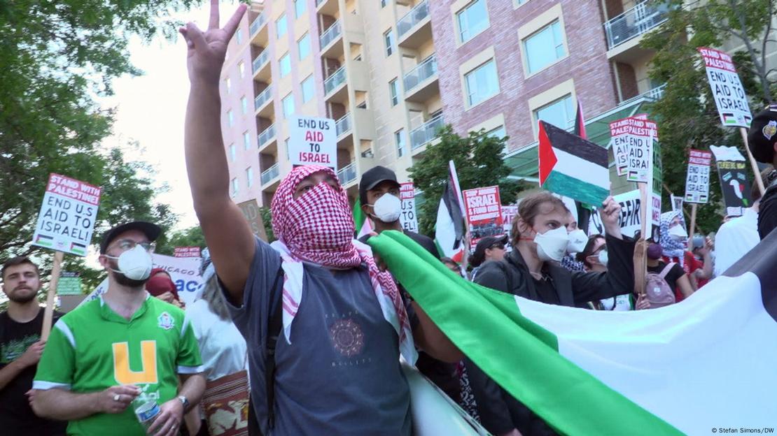 Demonstranten mit Protestplakaten, palästinensischen Fahnen, teilweise mit Masken im Gesicht