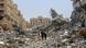 A family walking through the rubble of destroyed buildings in Khan Younis A family walking through the rubble of destroyed buildings in Khan Younis