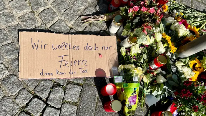 Uma mensagem, flores e velas depositadas em homenagem às vítimas