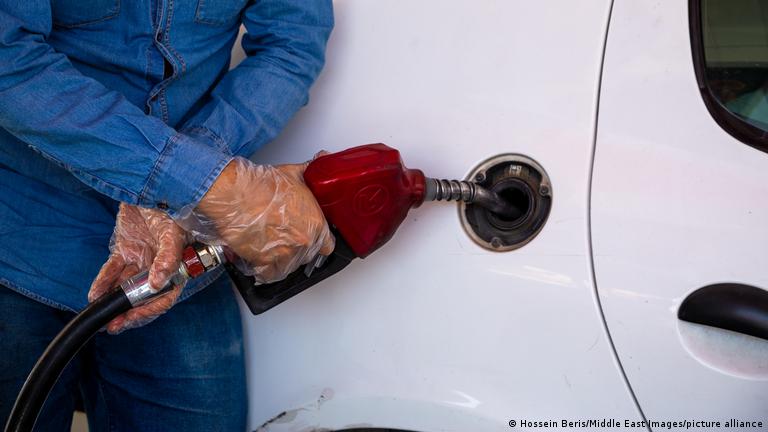 مردی در حال سوخت‌رسانی به خودرو در یک پمپ بنزین در تهران