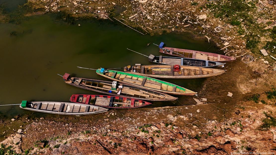 Barcos atracados em rio com nível de água baixo 