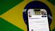 Tela de celular mostra a conta de Alexandre de Moraes na rede social X. Ao fundo, a bandeira brasileira Tela de celular mostra a conta de Alexandre de Moraes na rede social X. Ao fundo, a bandeira brasileira